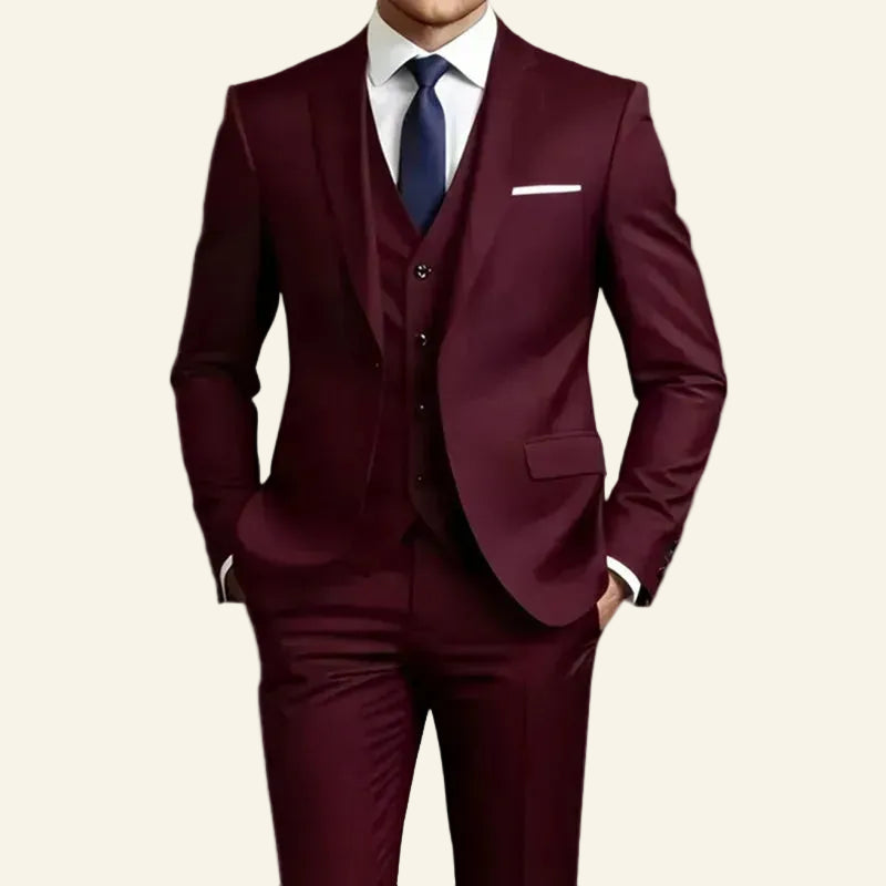  slim-fit three-piece burgundy suit with a white dress shirt and a navy blue tie, shown from the neck down 